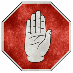 Octagonal stop sign with picture of raised hand